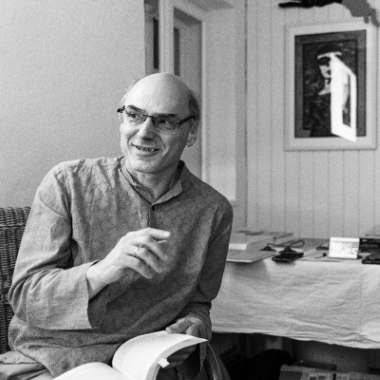 Christian in schwarz-weiß hält ein Buch in einer Hand und gestikuliert mit der anderen