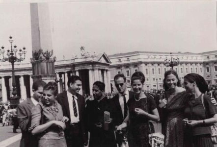 Eine Gruppe von acht Menschen in einem schwarz weiss Foto. Ein paar lächeln in die Kamera und andere wirken abgelenkt.